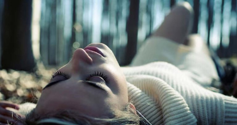 Cuplu stând de vorbă relaxat pe canapea, discutând deschis și cu empatie despre găsirea unor soluții pentru problemele din viața lor intimă.
